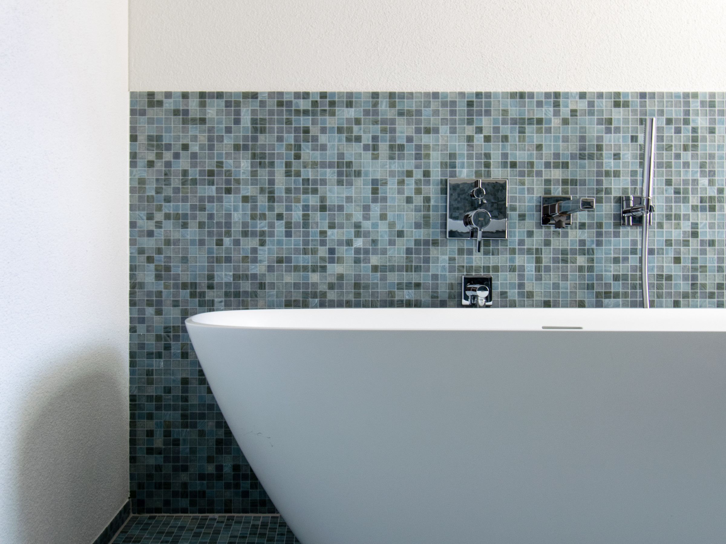 Freistehende Badewanne mit blauen Mosaikplatten