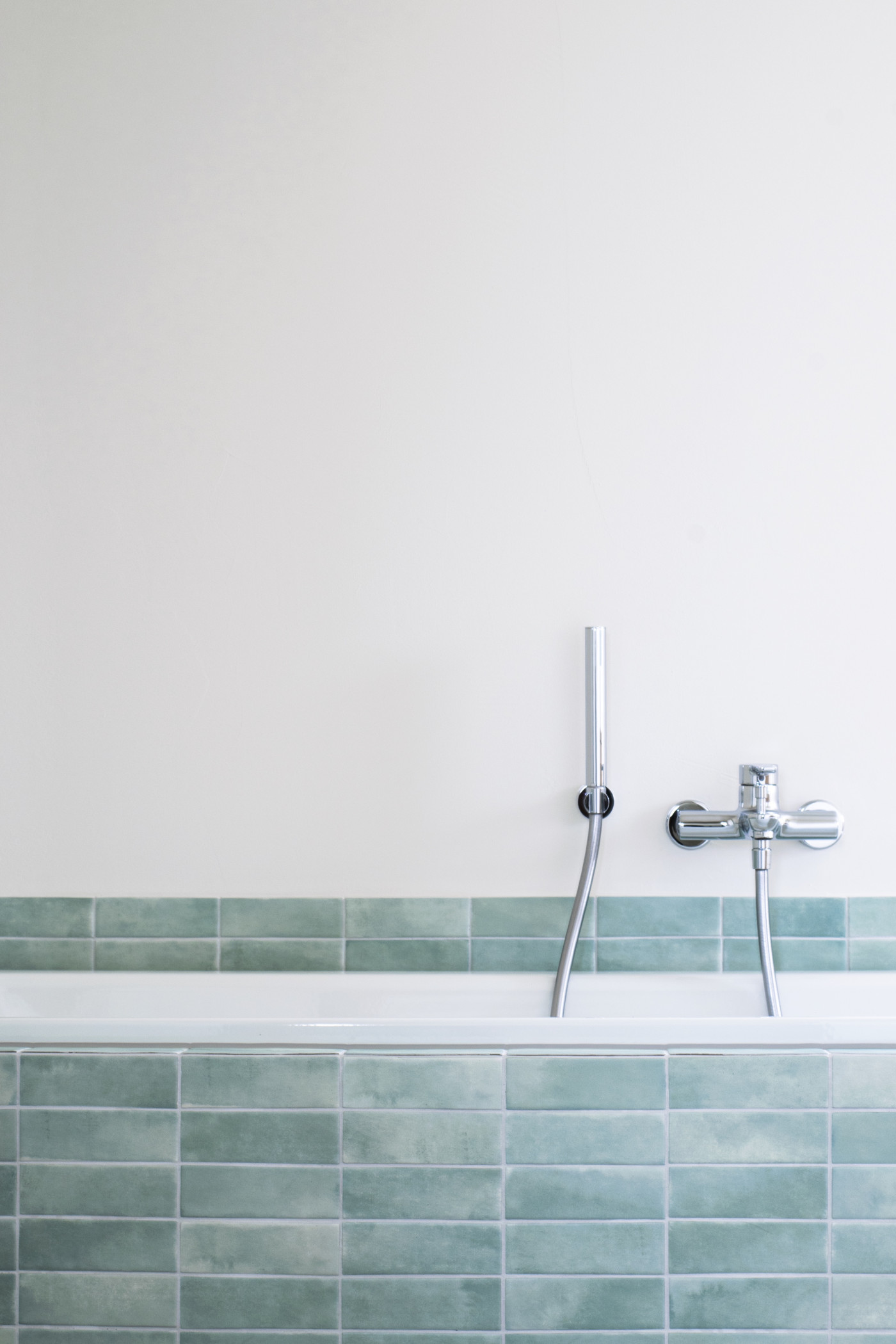 Detailfoto der Badwanne mit hellblauen Platten